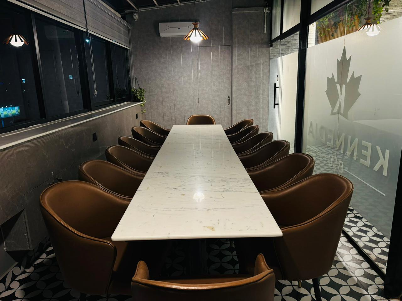 Private dining room with long marble table and brown chairs