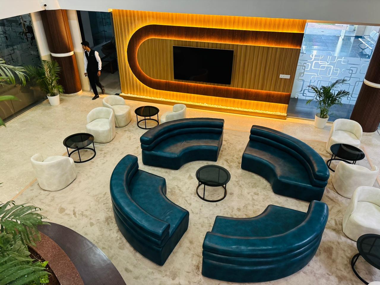 Commercial lobby lounge with curved blue sofas and illuminated wood wall