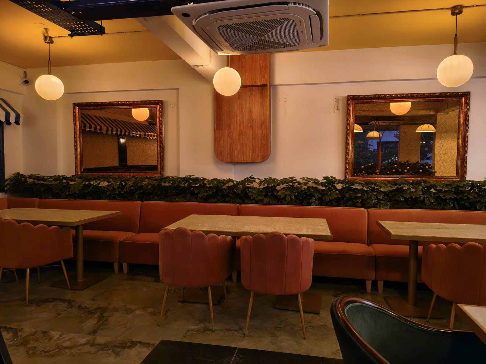 Restaurant seating with framed mirrors and pendant lighting