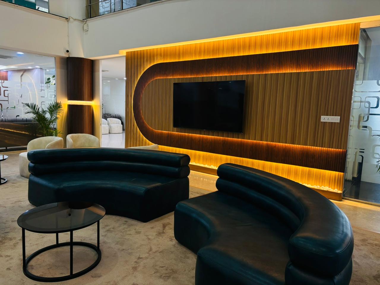 Commercial lounge with curved sofas and illuminated feature wall