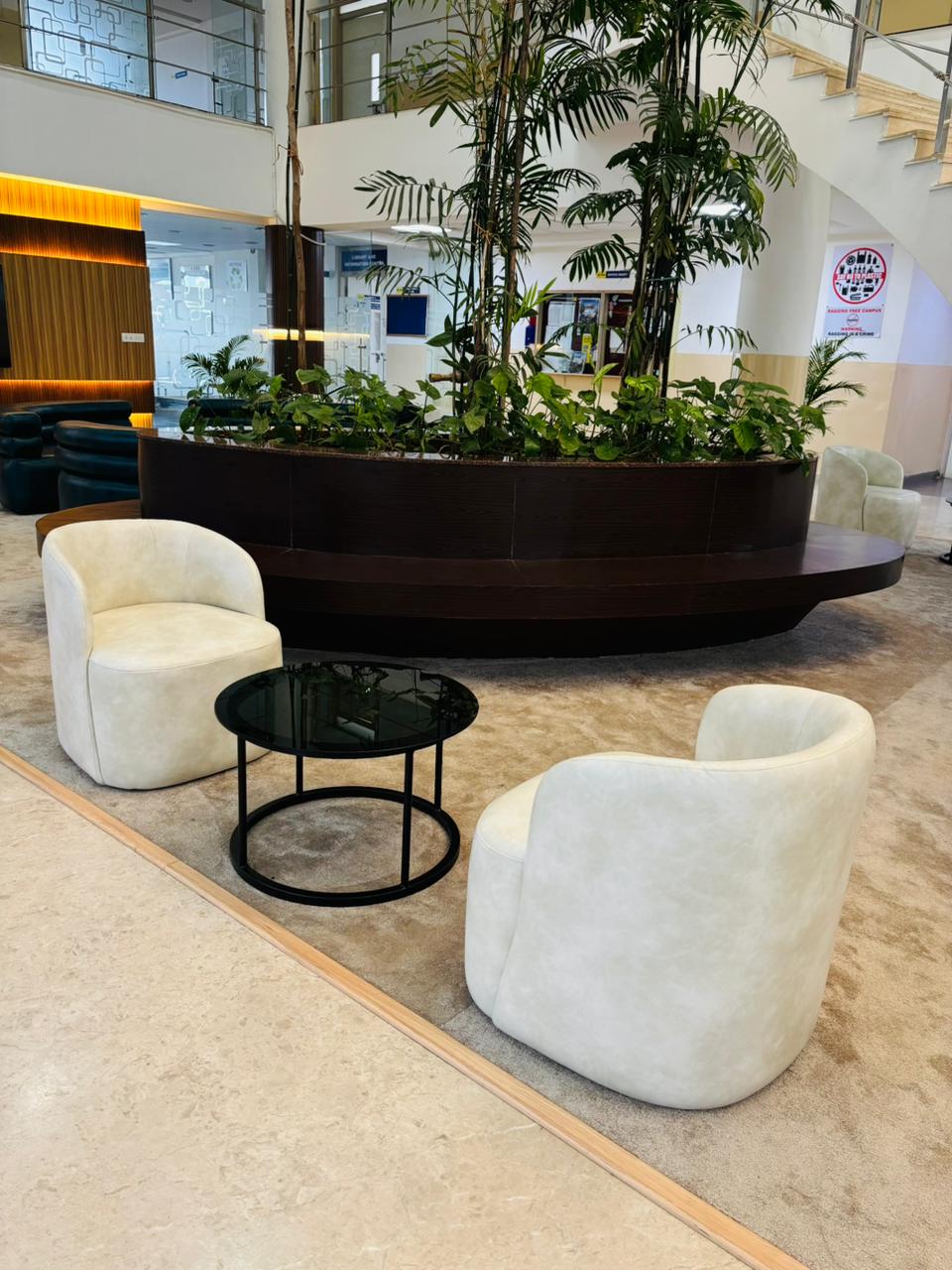 Lobby seating with indoor planter and white lounge chairs